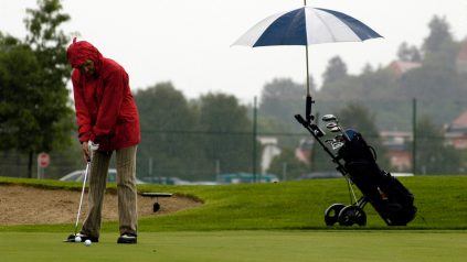 Man playing golf in rain wearing waterproof golf jacket