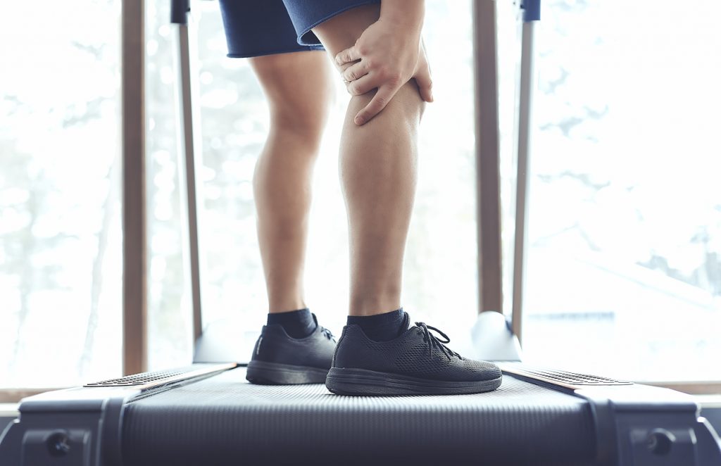 Personal trainer holding their knee after sustaining an injury. 