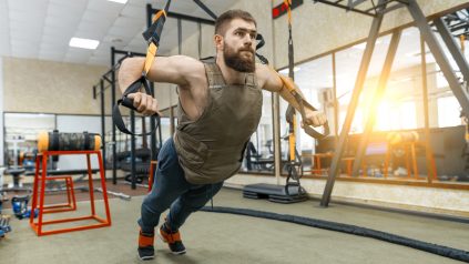 Man wearing weighted vest in gym with sun shining through