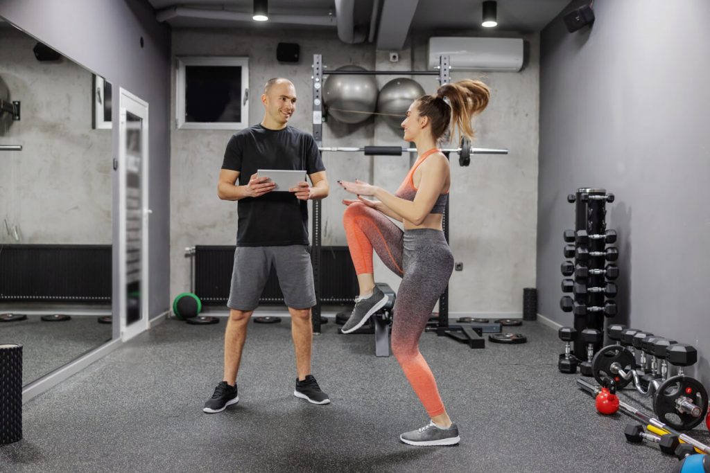 image of a personal trainer and their client performing a fitness assessment in a gym