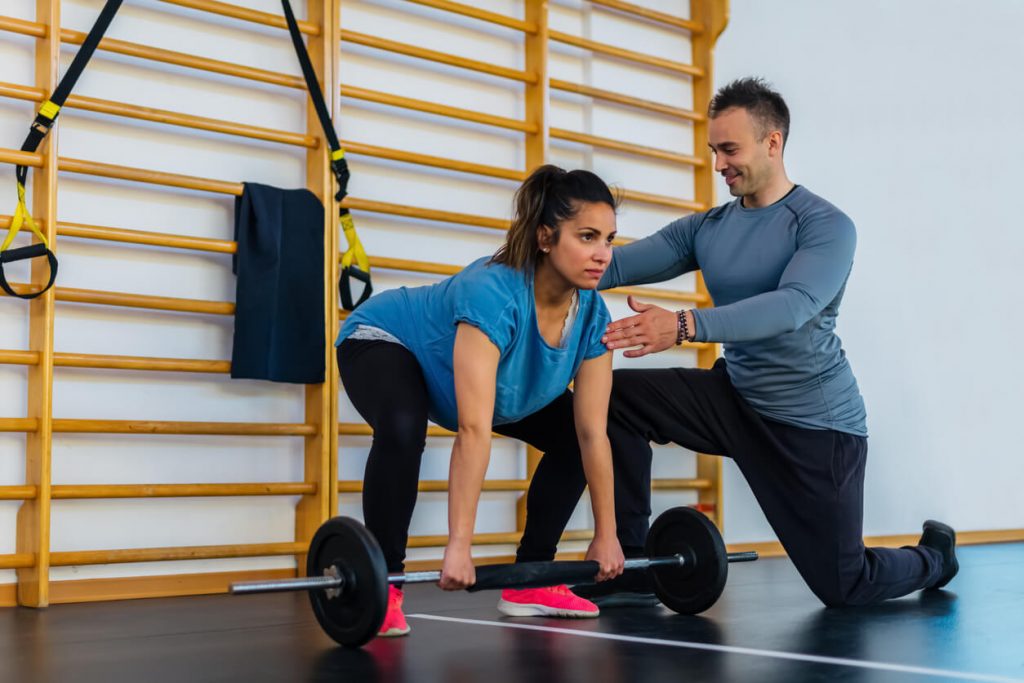 fitness professional instructing their client through a deadlift