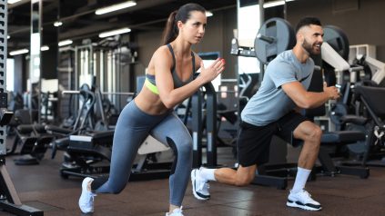 male and female trainers performing walking lunges