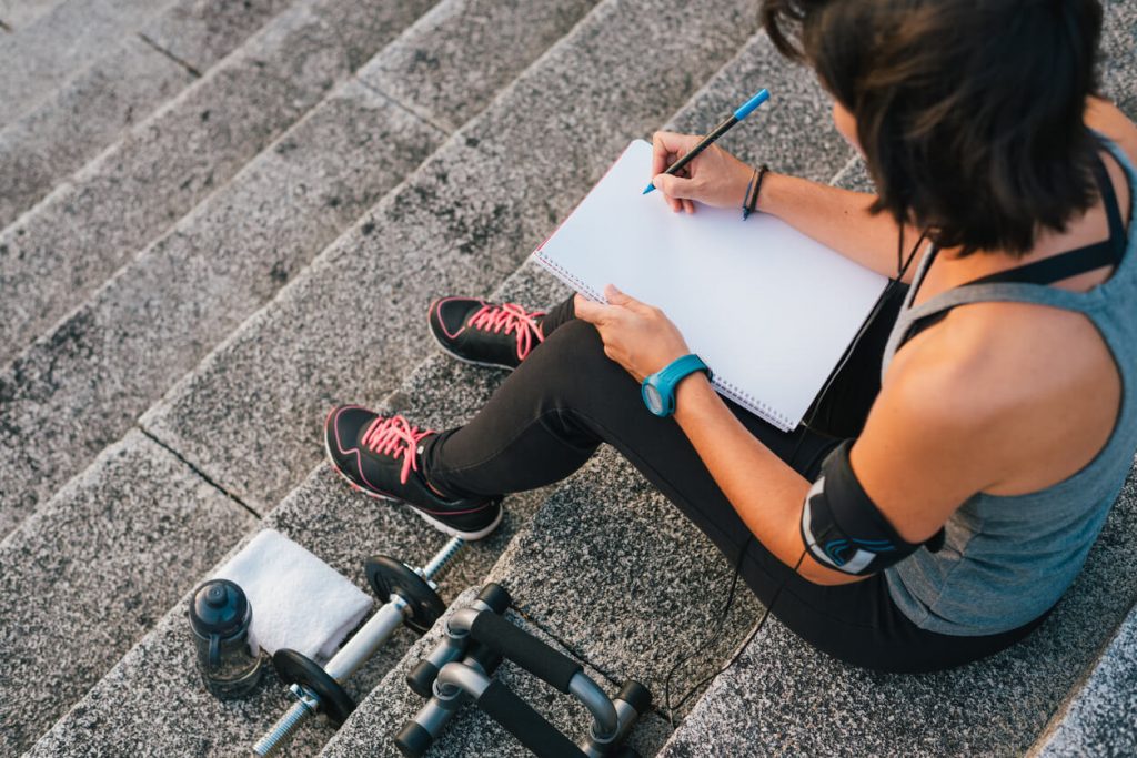 Woman setting fitness goals using a clipboard