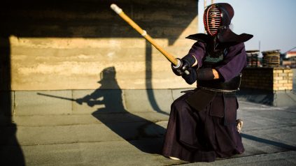image of a kendo martial artist in kendo gear holding a wooden sword