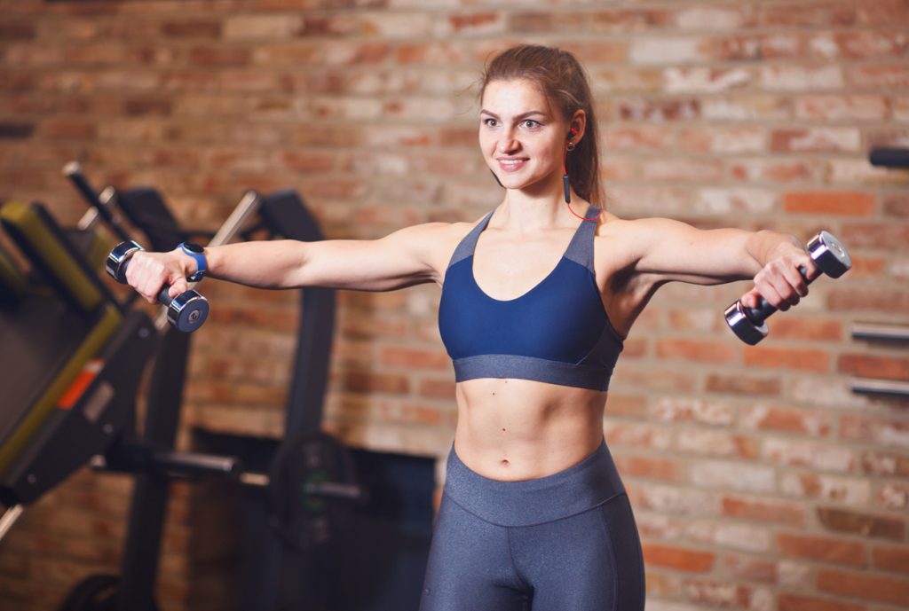 woman PT performing a lateral raise