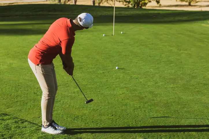 Man putting on a golf green
